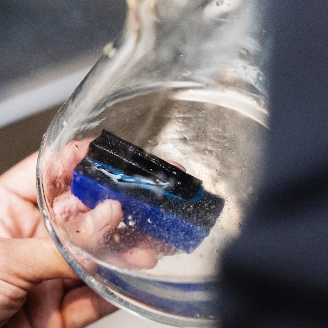 Close-up view of BoroBuddy™ Magnetic Cleaner in action inside a glass bong