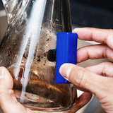 Close-up of hands using the illadelph x BoroBuddy™ Magnetic Cleaner on a bong