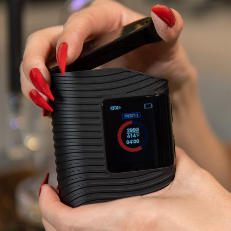 Boundless CFX+ Dry Herb Vaporizer with 2500mAh battery, held in hand showing digital display