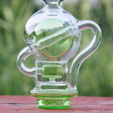 Calibear Ball Rig Carta Attachment with clear glass and green base, front view on wooden surface