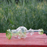 Calibear Exosphere Puffco Peak Glass Top in clear with green accents, bubble design, outdoor view