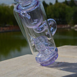 Calibear Puffco Attachment Klein in purple and green, side view on outdoor background
