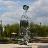 Calibear Puffco Attachment Klein in clear glass with green accents, outdoor side view