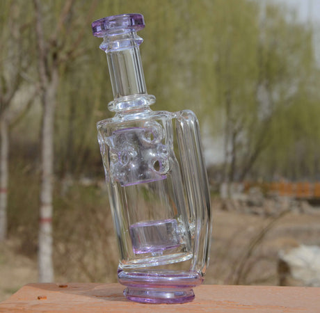 Calibear Straight Fab Puffco Attachment in purple, clear glass with intricate design, outdoor side view