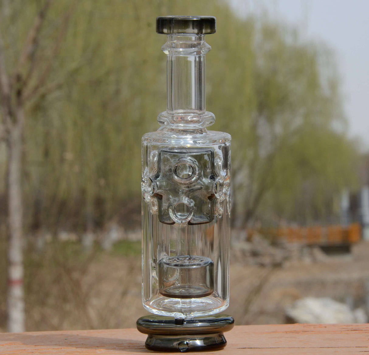 Calibear Straight Fab Puffco Attachment in clear glass, front view on wooden surface