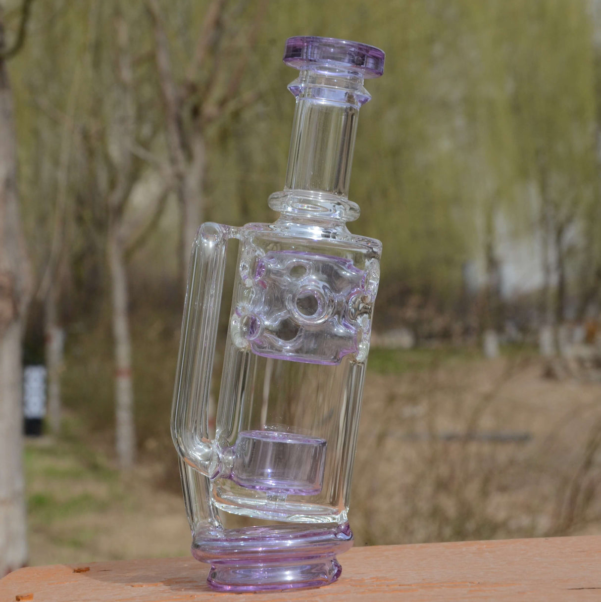 Calibear Straight Fab Puffco Attachment in clear and purple glass, outdoor side view