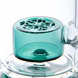 Calibear Straight Fab Puffco Attachment in teal, close-up side view on clear glass