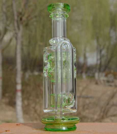 Calibear Straight Fab Puffco Attachment in green, clear glass, front view on wooden surface