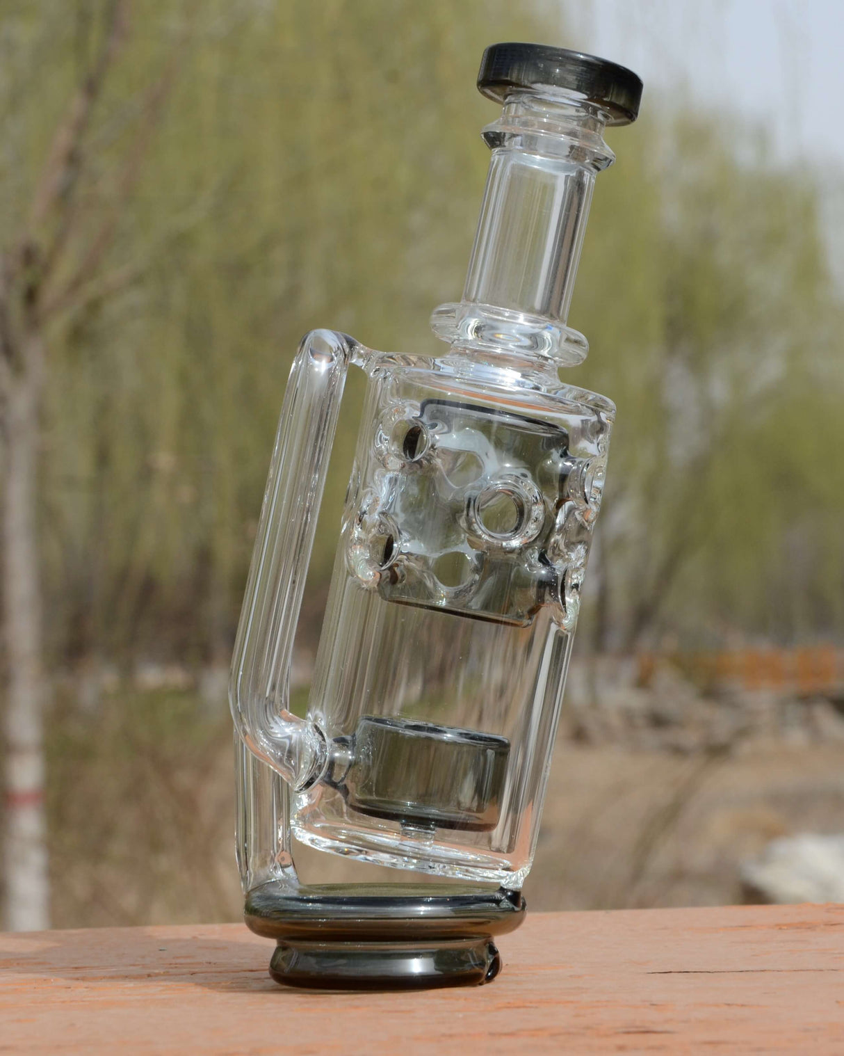 Calibear Straight Fab Puffco Attachment in Clear Glass - Side View on Wooden Surface