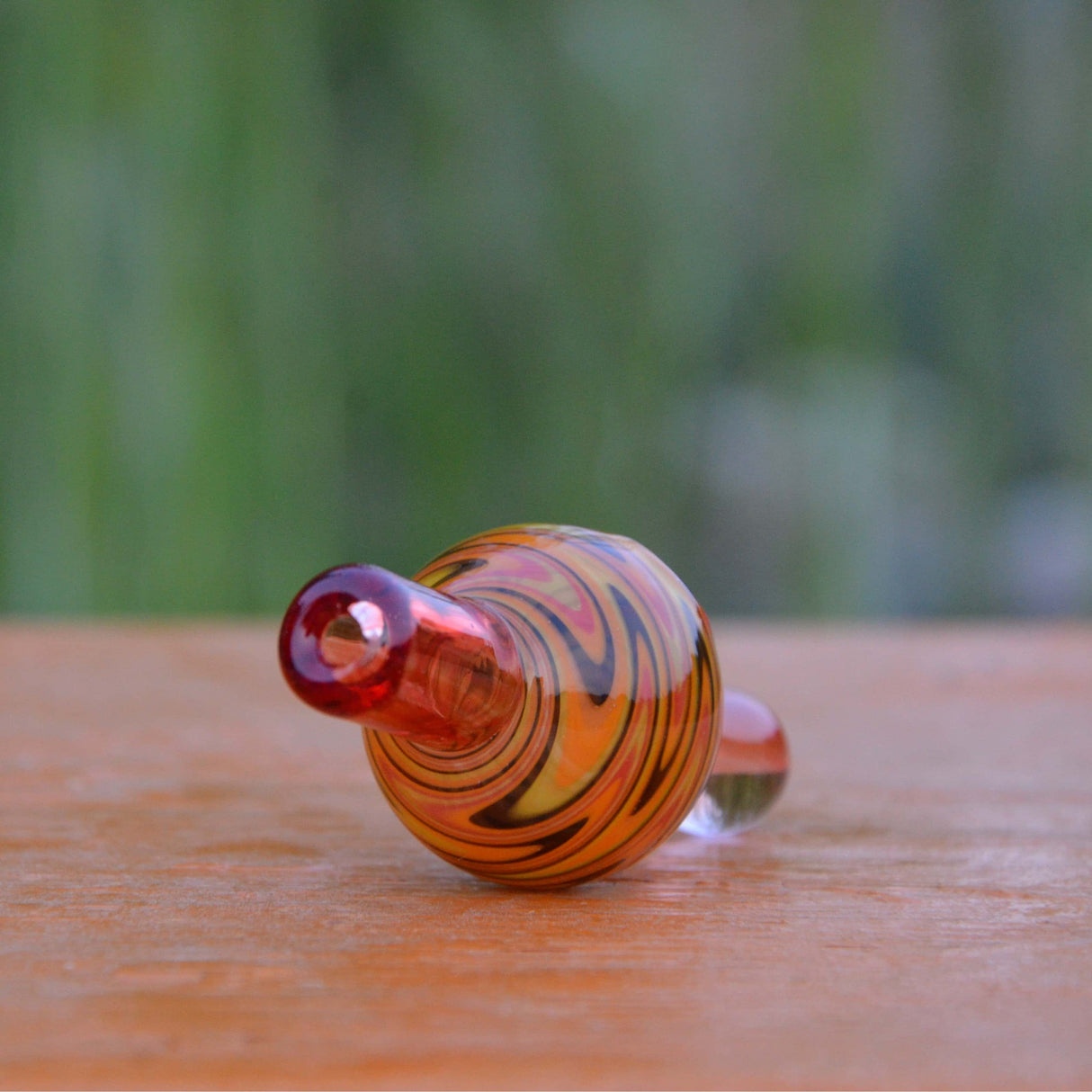 Calibear Wigwag Bubble Carb Cap in high-quality borosilicate glass, side view on wooden surface