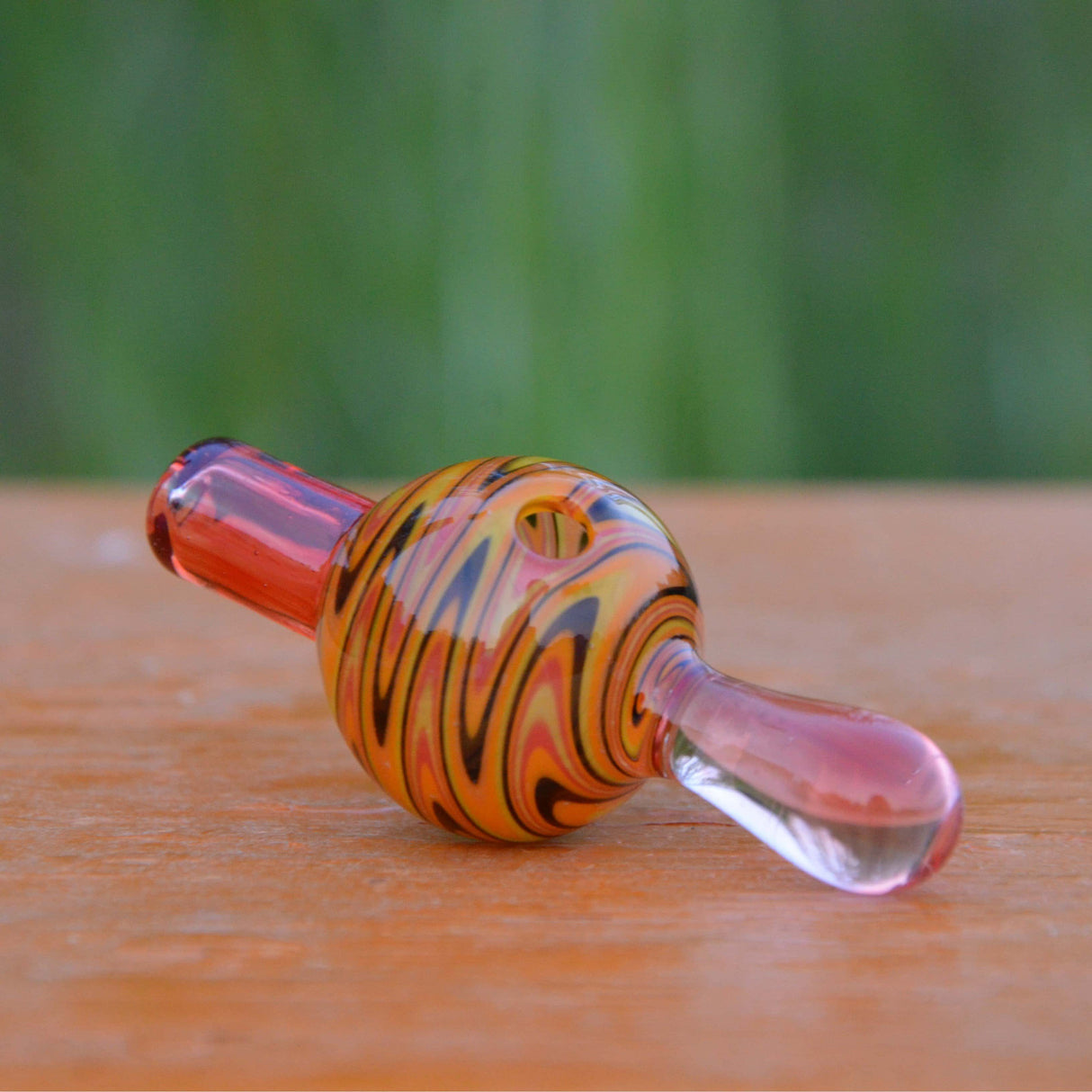 Calibear Wigwag Bubble Carb Cap in Borosilicate Glass - Side View on Wooden Surface