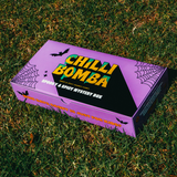 Chilli Bomba's Spooky & Spicy Mystery Box, vibrant purple packaging with Halloween motifs, outdoor shot