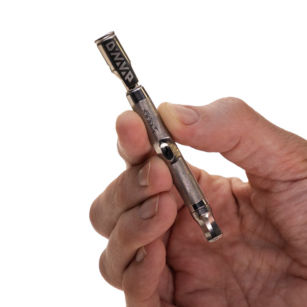 DynaVap The M 7 XL vaporizer held in hand against a white background, showing its size relative to a hand.