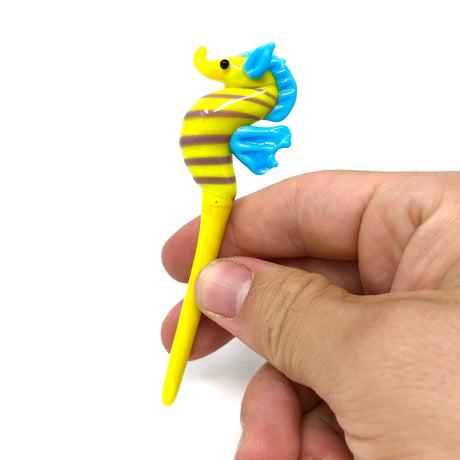 AFM Seahorse Glass Dabber Tool in hand, vibrant yellow with blue accents, for dab rigs