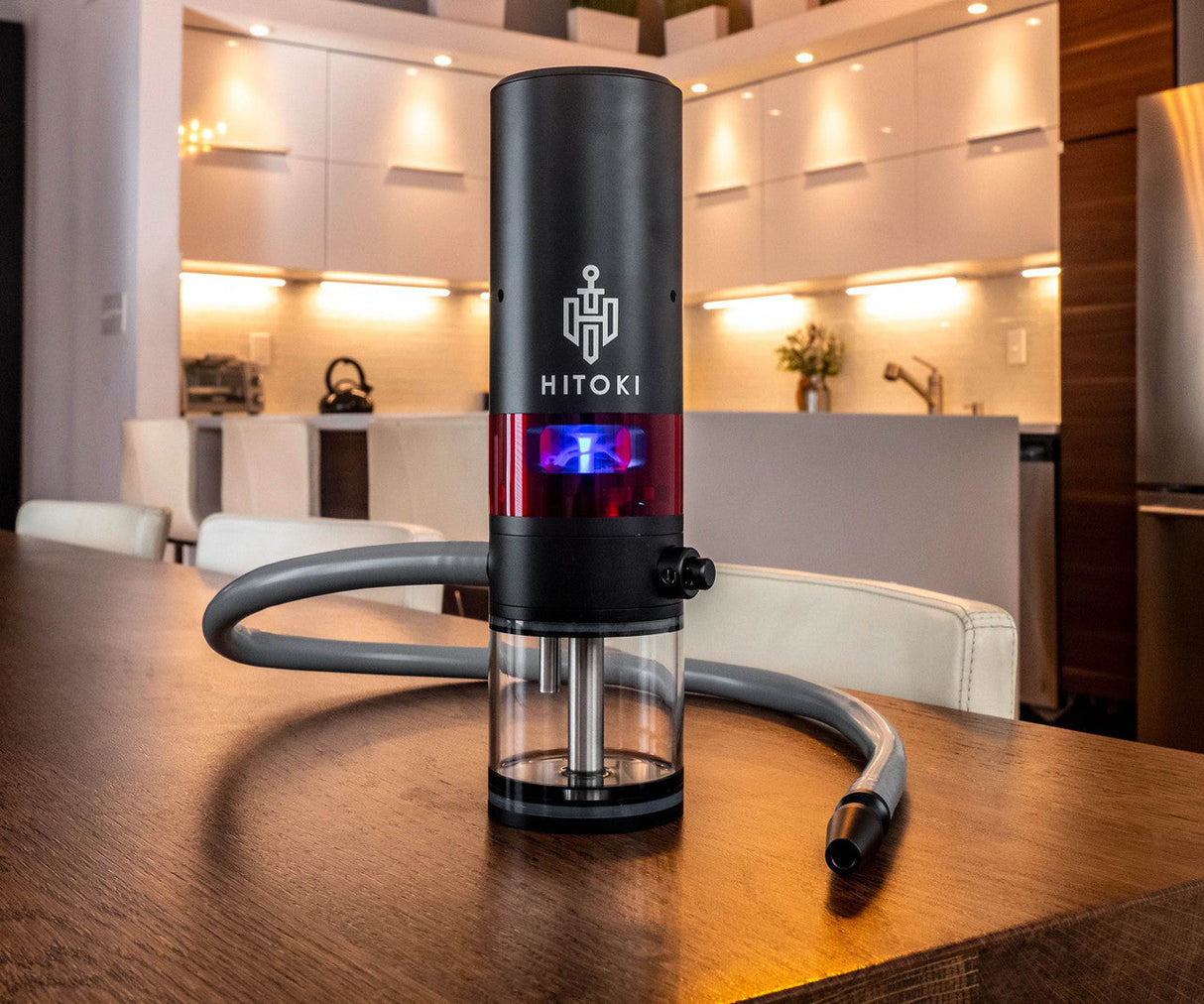 Hitoki Trident Laser Water Pipe 2.0 in Black with blue light, on wooden table, modern kitchen background