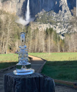 Beta Glass Labs Petra XL clear dab rig with showerhead percolator, outdoor nature backdrop