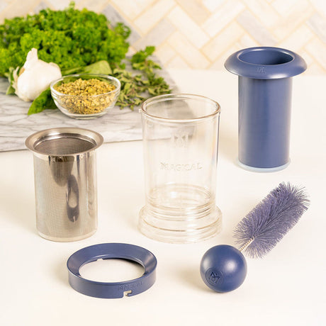 Magical Butter Filter Press set with glass container, filters, and cleaning brush on kitchen counter