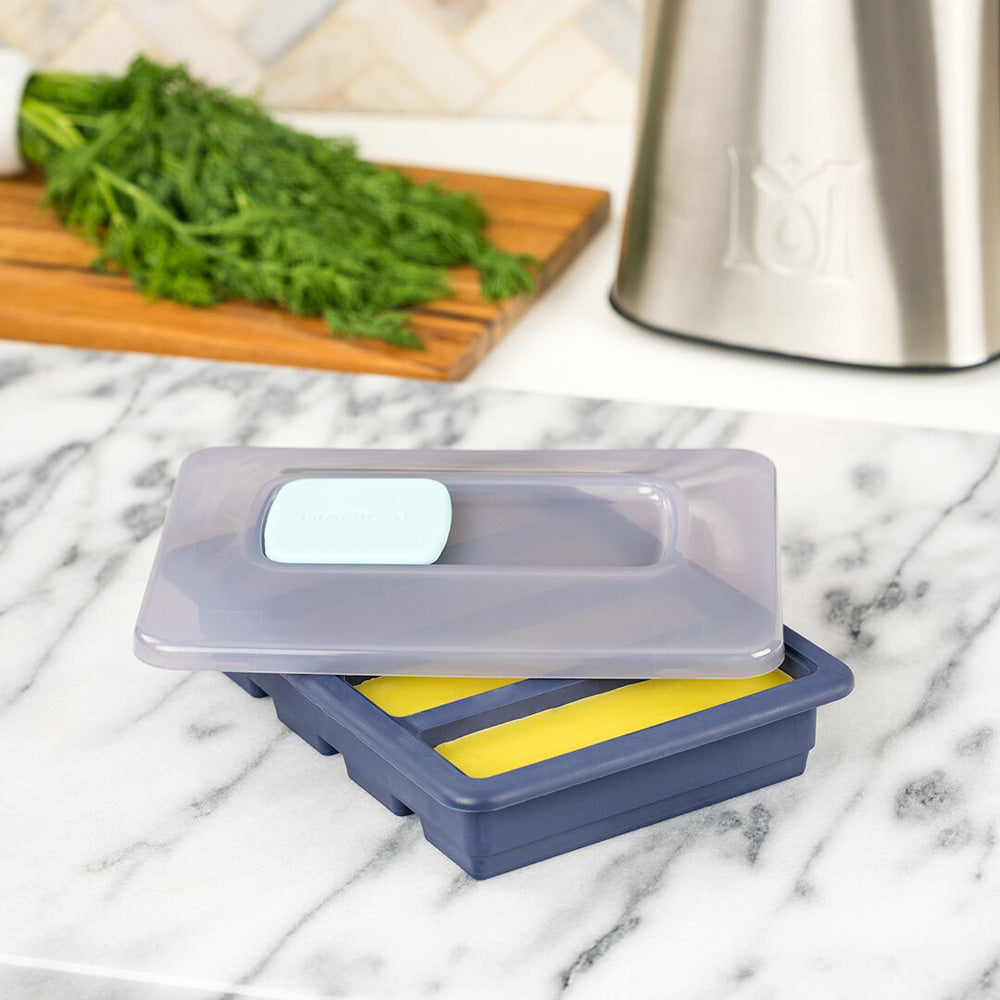 Magical Butter Silicone Tray with Lid on marble countertop, ideal for herb storage