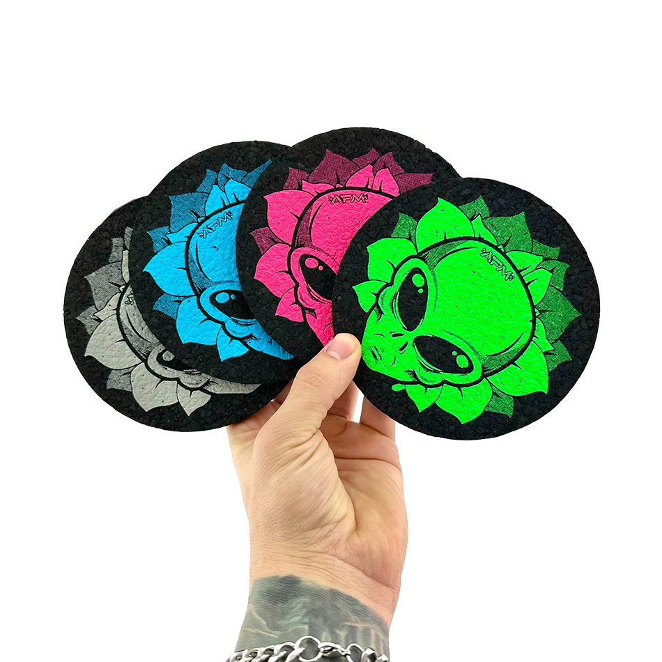 Hand holding three 5" AFM Alien Head Circle Mood Mats in blue, pink, and green