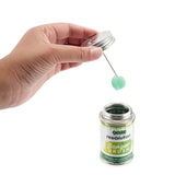 Hand holding Ooze Resolution Banger Brush with green bristles over open container