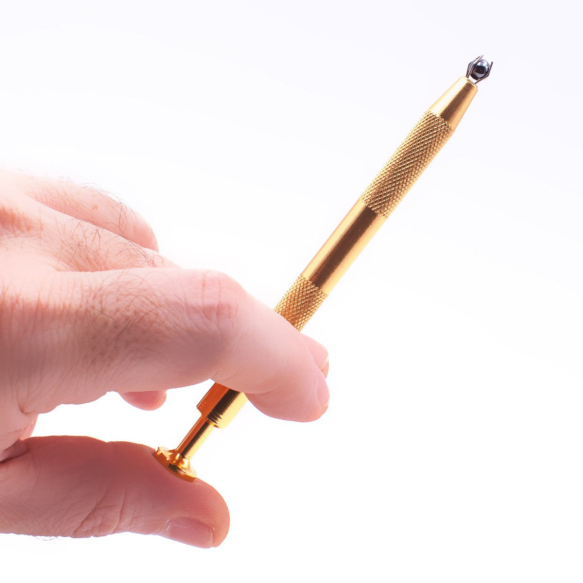 Hand holding The Stash Shack Pearl Grabber Tool for concentrates, gold finish, close-up view