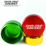 Santa Cruz Shredder Medium 3-Piece Grinder in Rasta colors, top view on white background