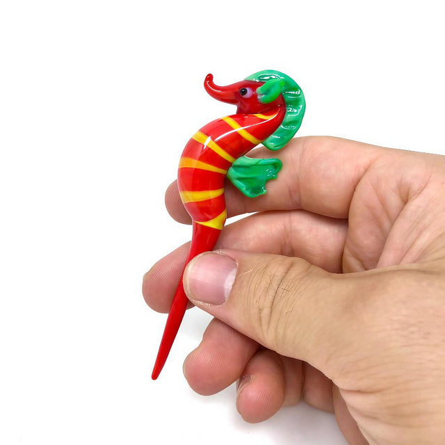 DankGeek Seahorse Dabber in hand, red with yellow stripes, borosilicate glass, front view
