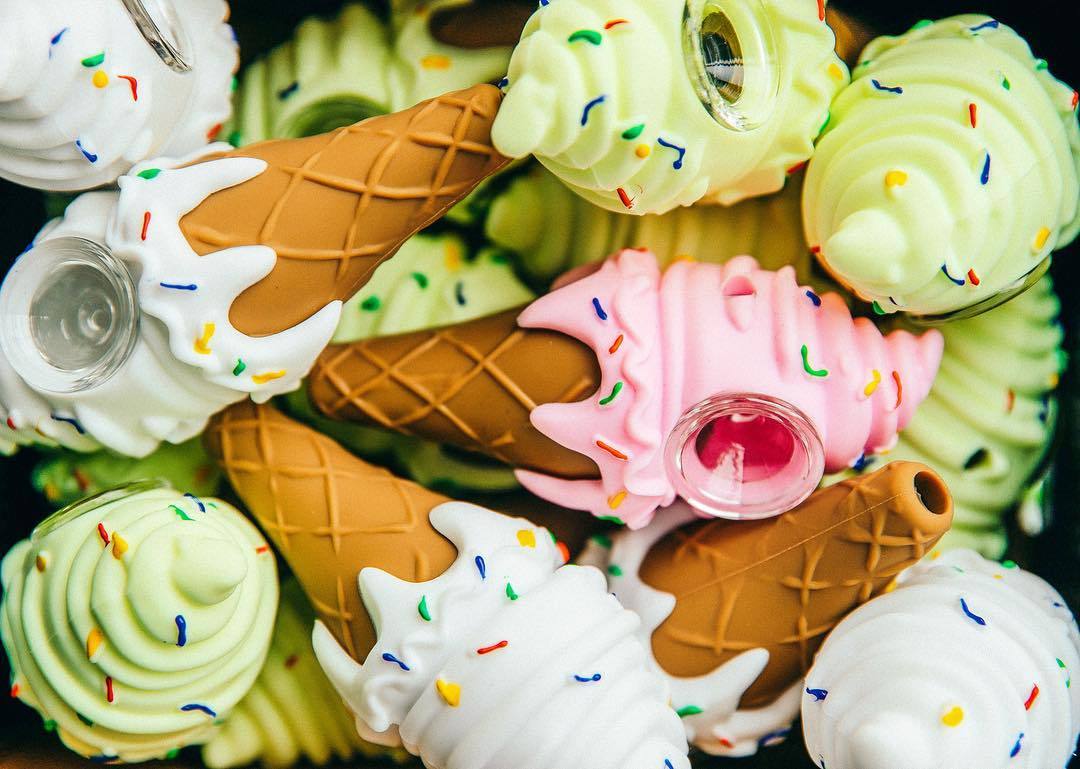 Assorted Silicone Ice Cream Pipes from DankGeek with colorful sprinkles, steel bowls, close-up view