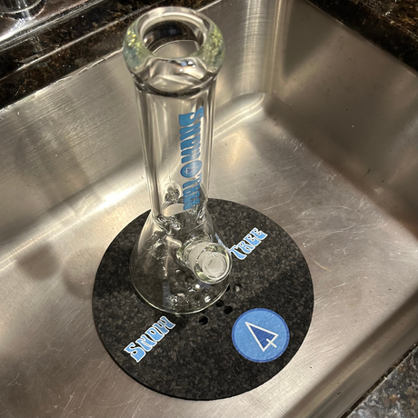 Snowtree Glass Sink Mat under a clear bong, top view, protecting kitchen sink surface