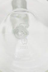 Close-up of TAG 12" Super Slit UFO Beaker logo on clear glass, highlighting the quality and design.