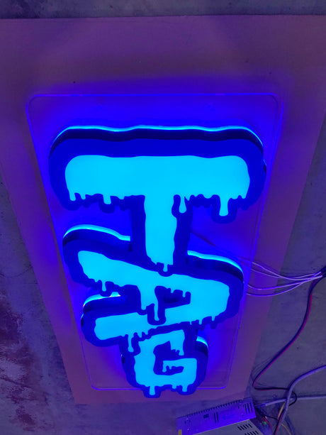 TAG - LED Sign with blue glow, showcasing Thick Ass Glass logo, wall-mounted display