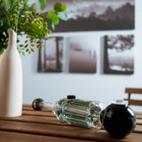 Freeze Pipe Steamroller on wooden table, angled view, clear glass with black accents