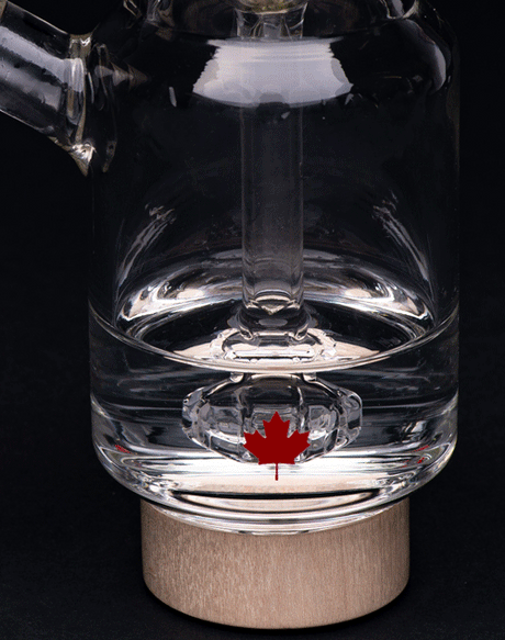 Canada Puffin Arctic Bubbler with clear glass and Canadian leaf emblem, front view on black background