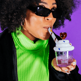 Person using Goody Cupcake Bubbler by Goody Glass, front view, with colorful background