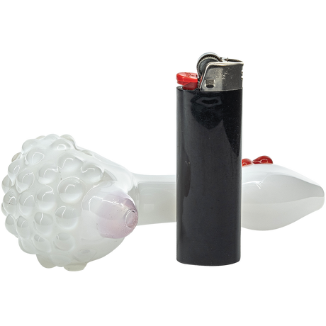 LA Pipes "White Heart" ivory glass spoon pipe with a deep bowl, side view next to a lighter