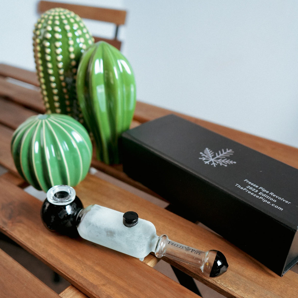 Freeze Pipe Revolver on wooden bench with sleek design and original packaging