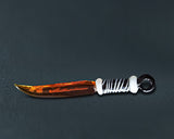 Honeybee Herb Glass Sword Dab Tool in Black, angled side view on dark background