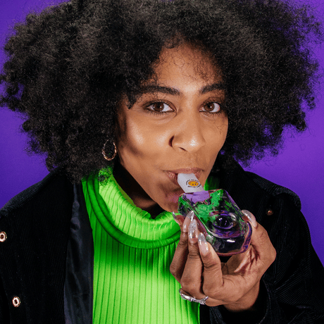 Woman using Goody Popsicle Hand Pipe by Goody Glass with vibrant background