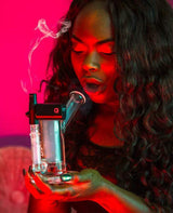 Woman using G-Pen Connect X Higher Standards Riggler Bundle, electric dab rig with sidecar design