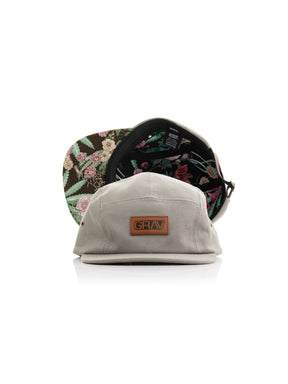 Front view of GRAV Camp Hat in brown with beaker design under brim, showcasing the GRAV logo