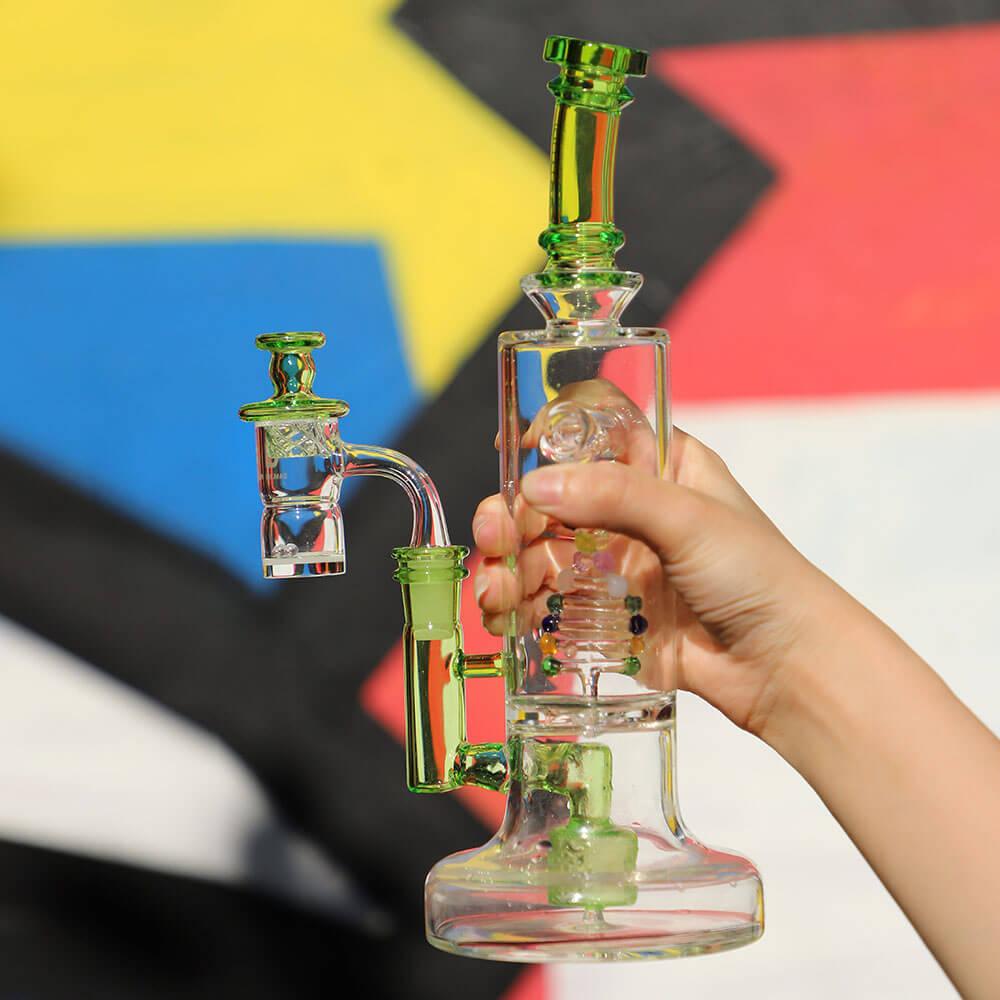 PILOTDIARY DNA Bong with intricate glasswork held in hand against colorful backdrop