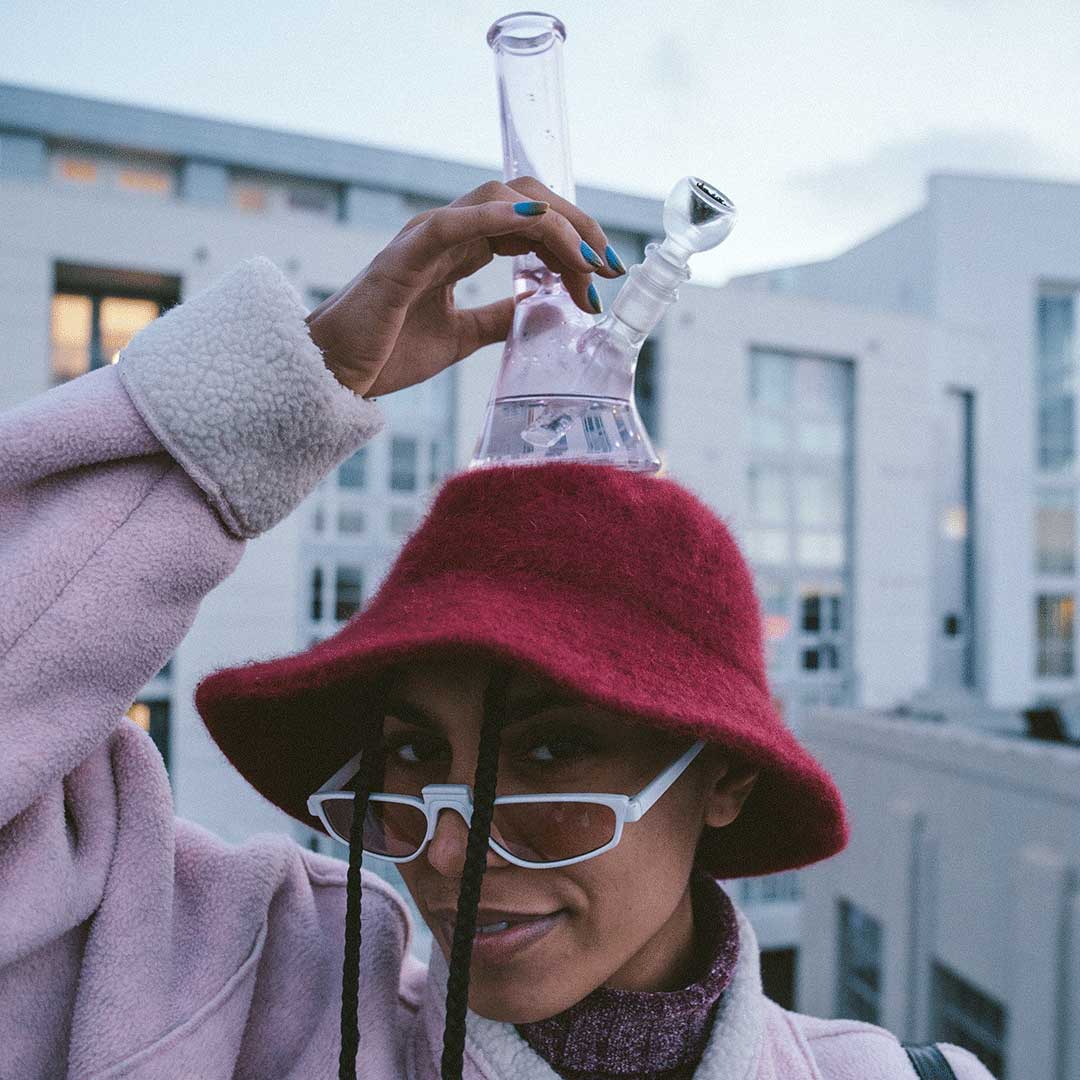 Woman holding Hemper Pink Beaker Bong with clear glass design, 9" height, and 14mm joint size