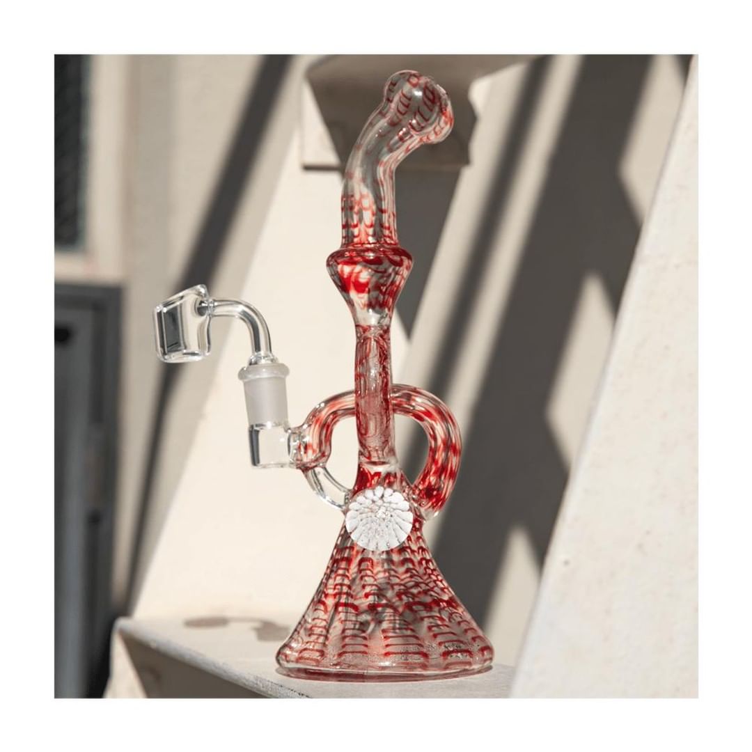 Hemper Snakeskin Bong in red with a unique twisted neck design, 9" tall, on a sunny ledge