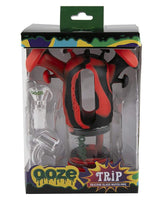 Ooze Trip Silicone Bubbler in Rasta color, front view in packaging with quartz bowl and percolator