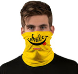 Front view of a person wearing a yellow Smile StonerDays Neck Gaiter with cannabis leaf pattern