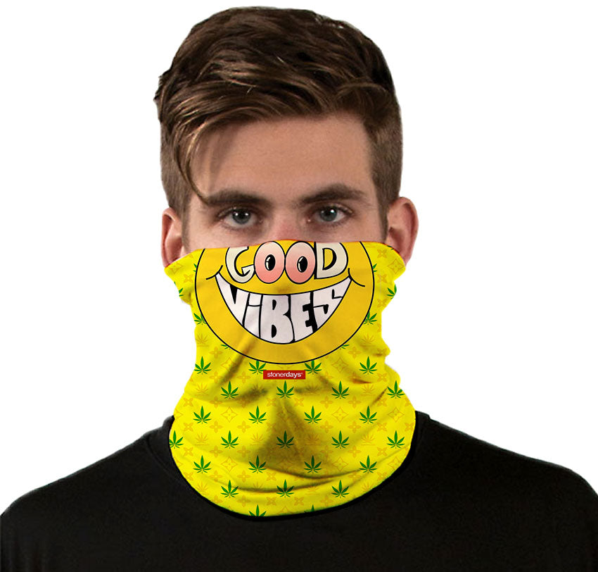 StonerDays Happy Face Good Vibes Neck Gaiter in yellow with cannabis leaves, front view on model