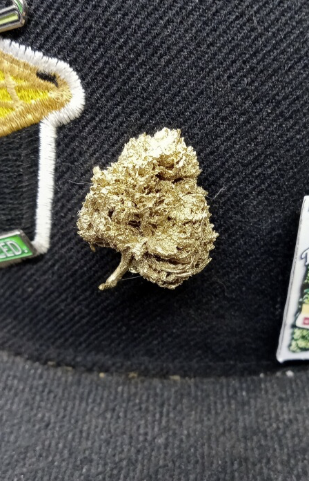 StonerDays Just Passin Thru Mylarpinz Pin, detailed cannabis bud design, on black fabric