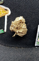 StonerDays Just Passin Thru Mylarpinz Pin, detailed cannabis bud design, on black fabric