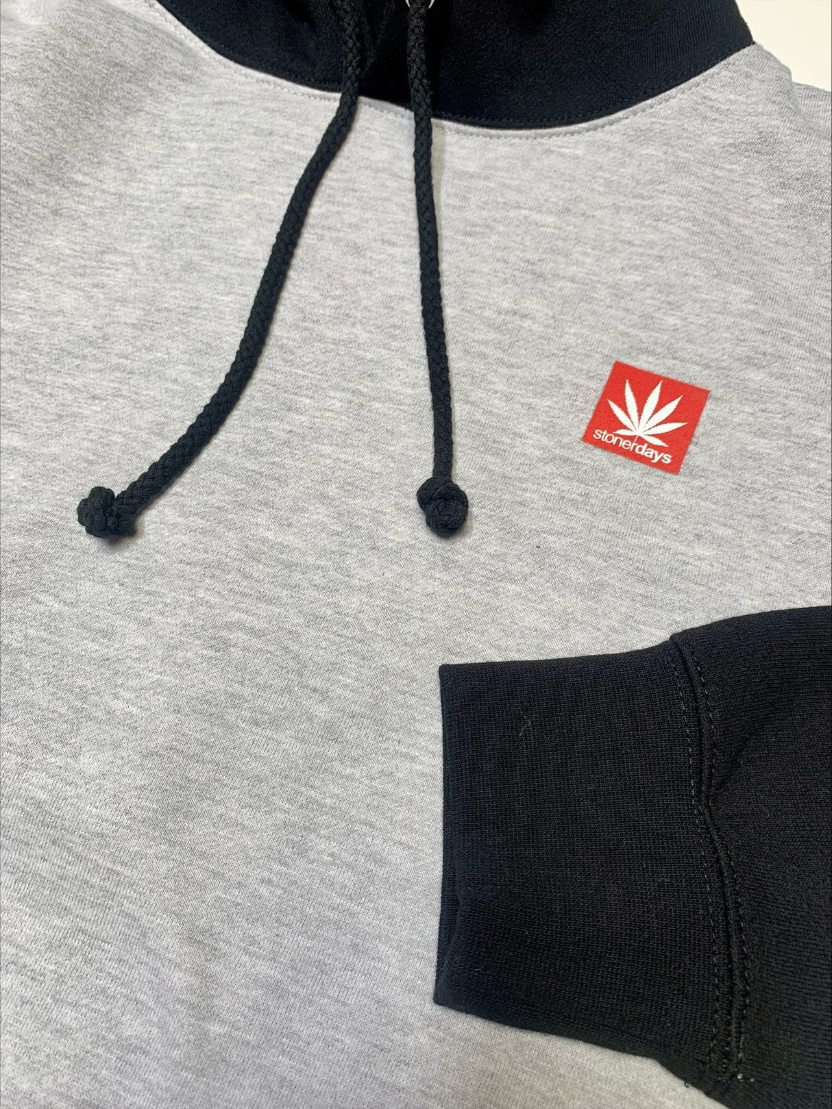 Close-up of StonerDays Two Tone Hoodie in small, featuring logo on gray and black fabric