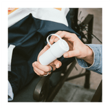 Person holding The Keeper™ by Hemper 3-part grinder in white, showcasing portability